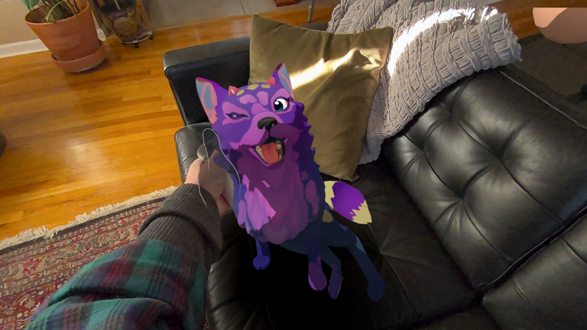 A digital purple fox sits on a real leather couch and is stroked by a human.