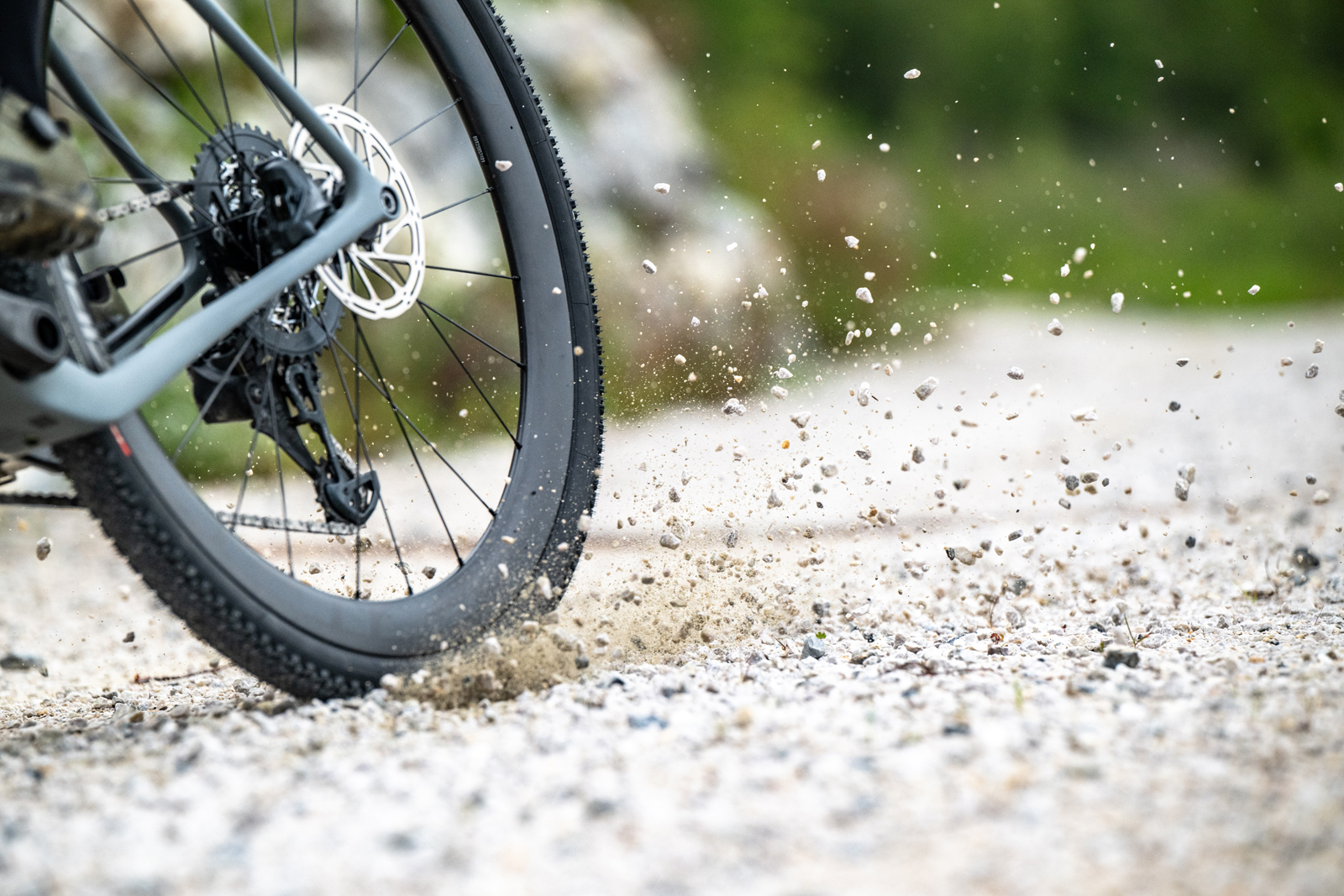Vittoria bike tyre doing skid and gravel flying in air.