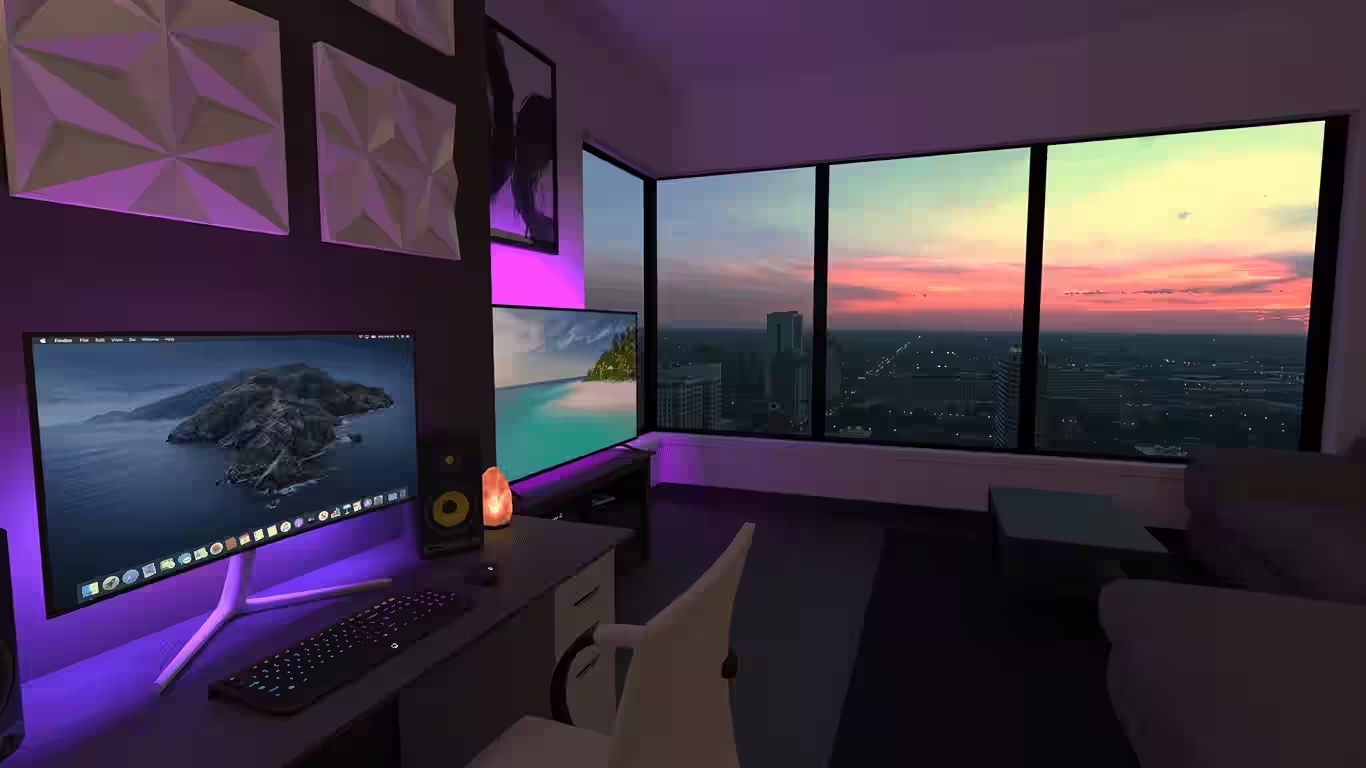 A monitor stands in a room. To the right of the monitor is a large window through which the sunset can be seen.