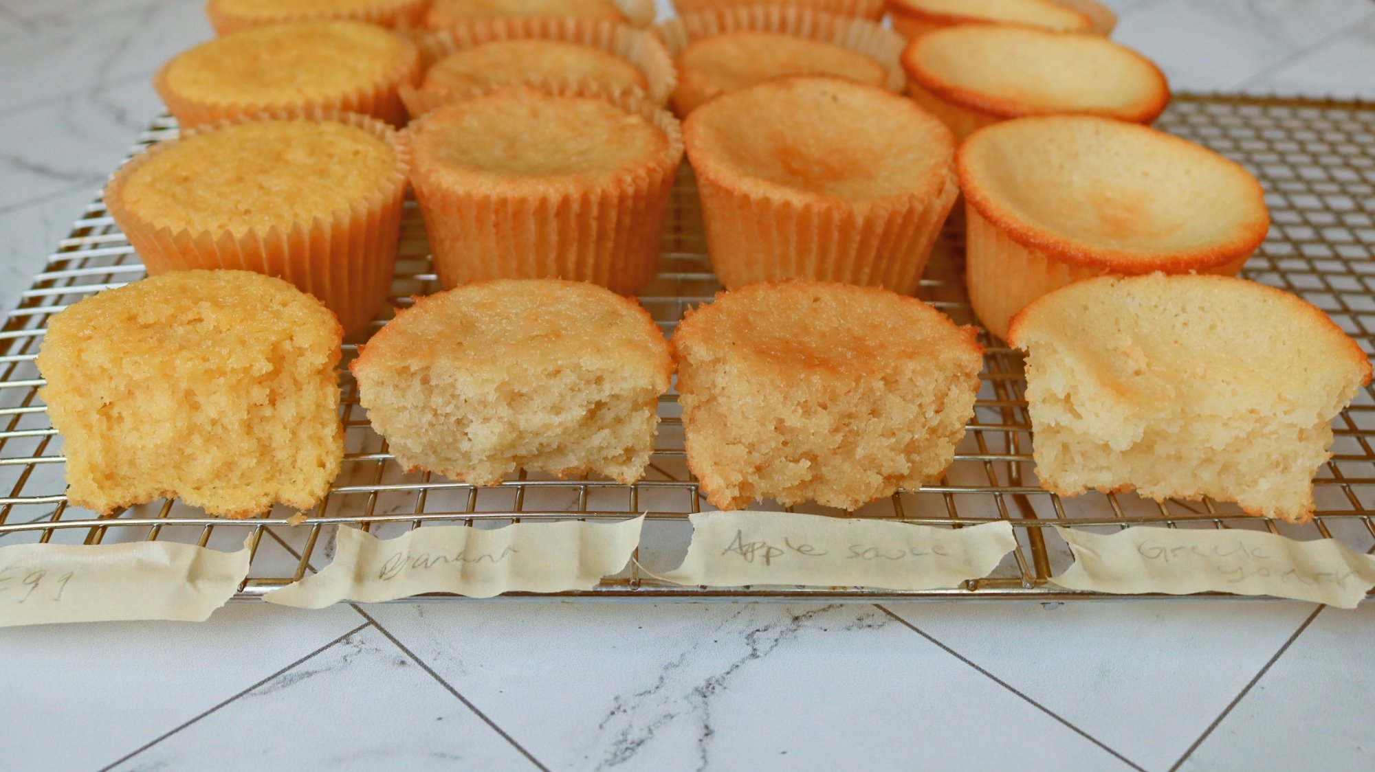 Four types of cupcakes on a wire rack.