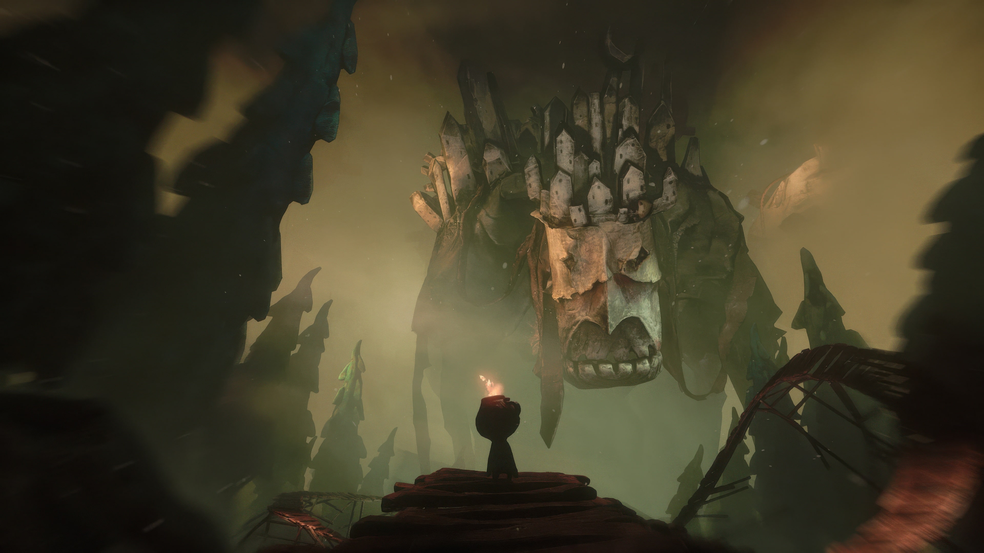Potboy stands in front of a huge, stone monster in a misty landscape.