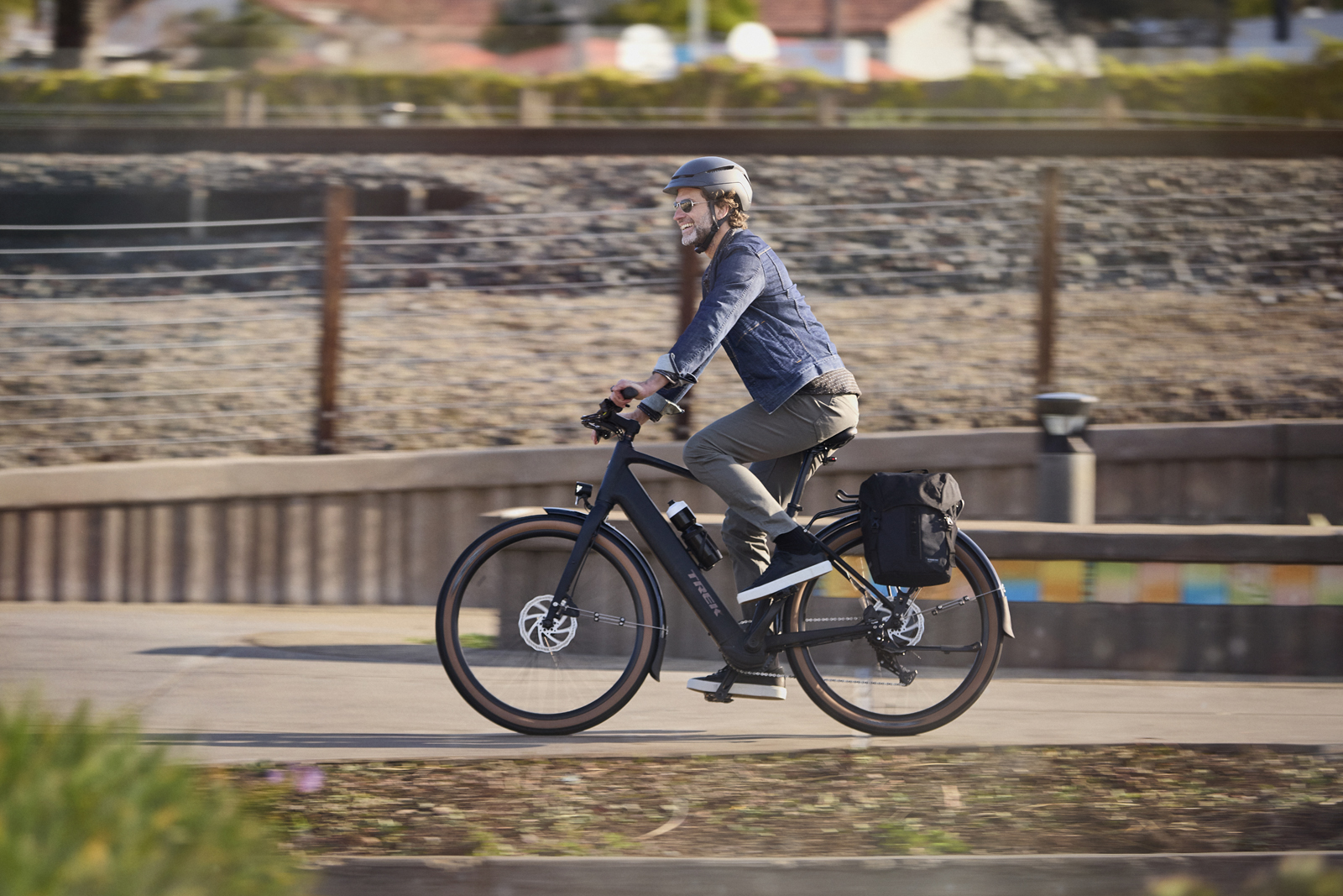 Man riding Trek FX 1 electric bike with panniers.