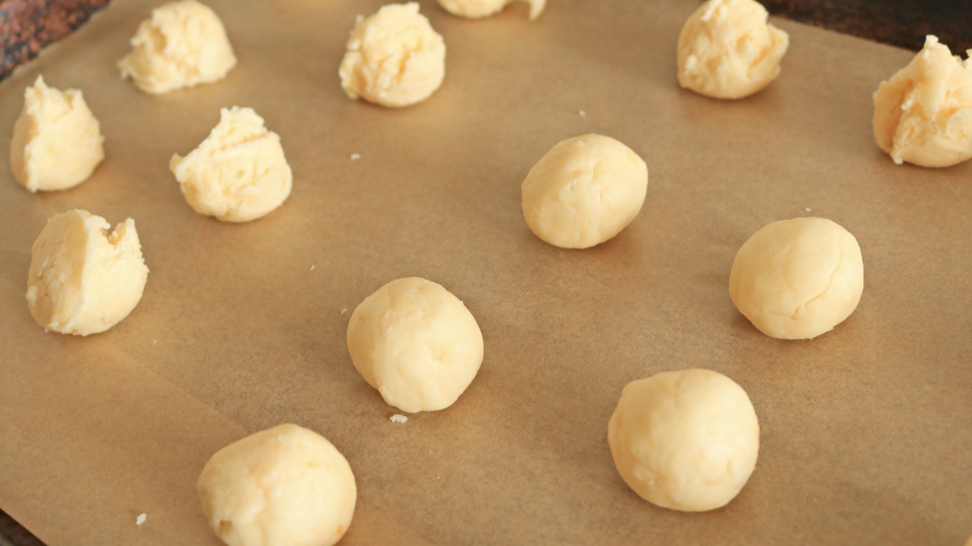 A sheet tray full of dough balls.