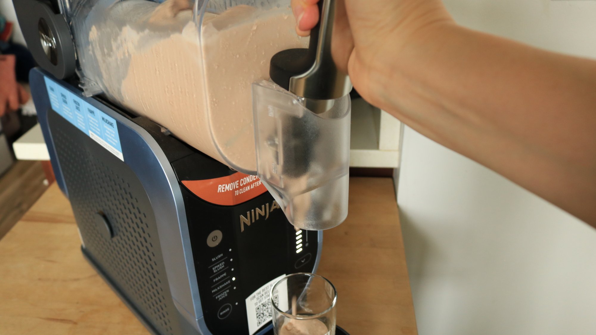 A person dispensing milkshake out of the Ninja Slushi.