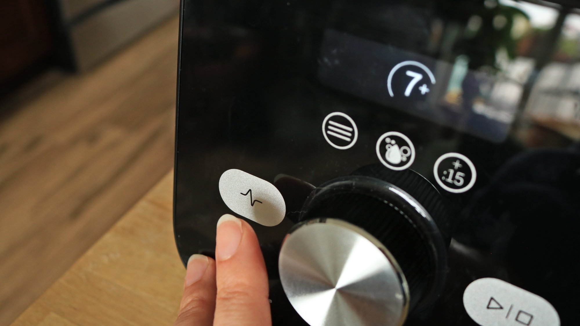 A finger pressing the pulse button on the Vitamix Ascent X5