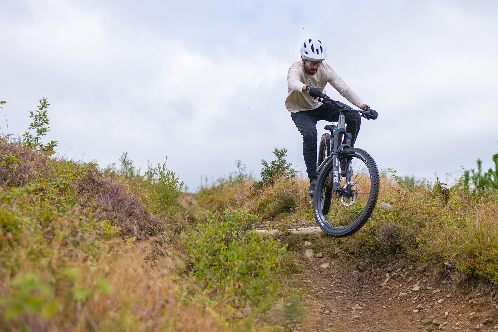 Male mountain biker in white top riding the Canyon Spectral AL 6 mountain bike