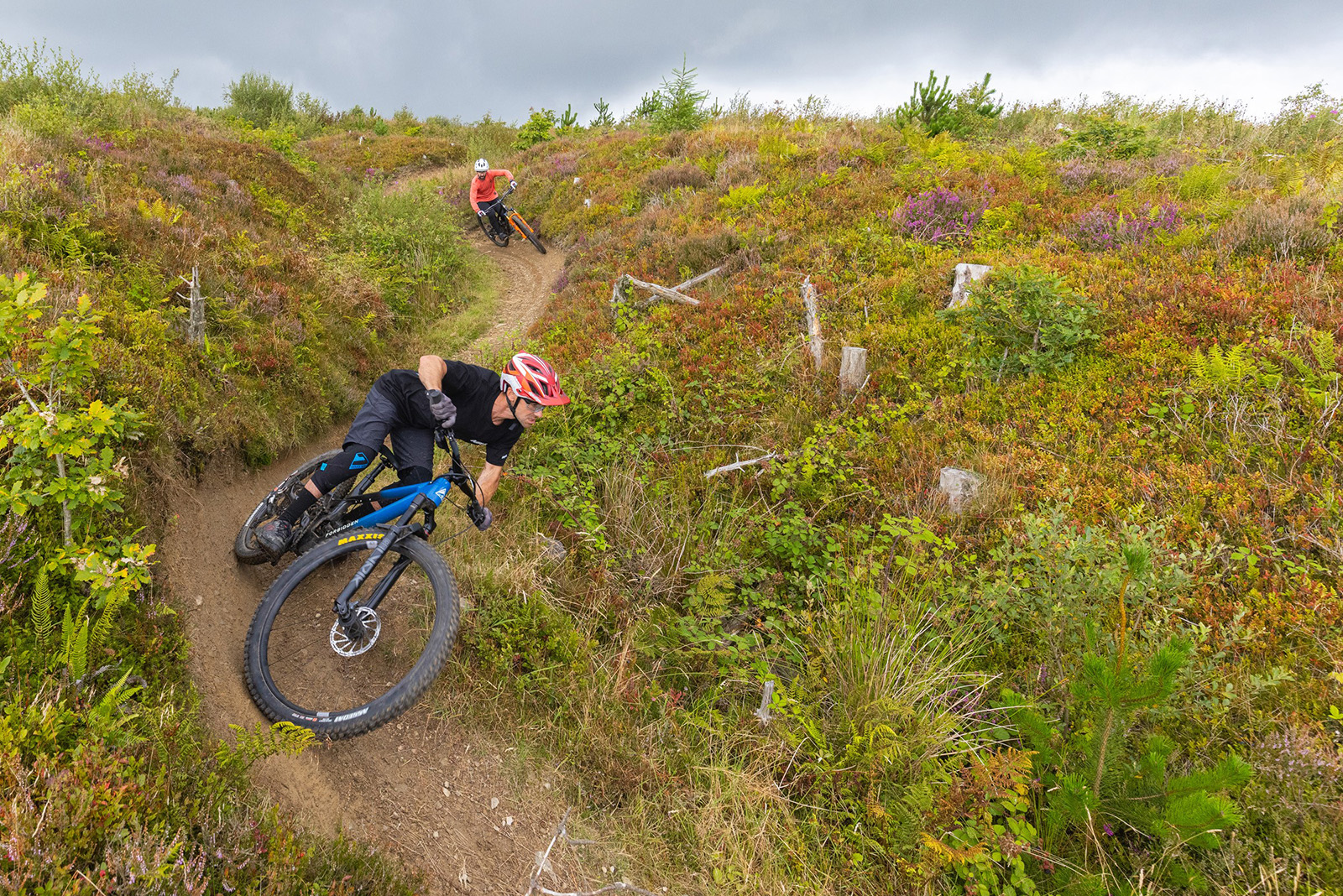 Two mountain bikers riding downhill on dirt track