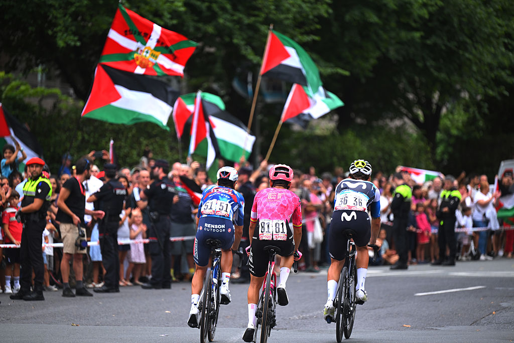 Cyclists pass Palestine flags at La Vuelta a España.
