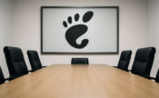 Empty boardroom table with Gnome logo on the wall.