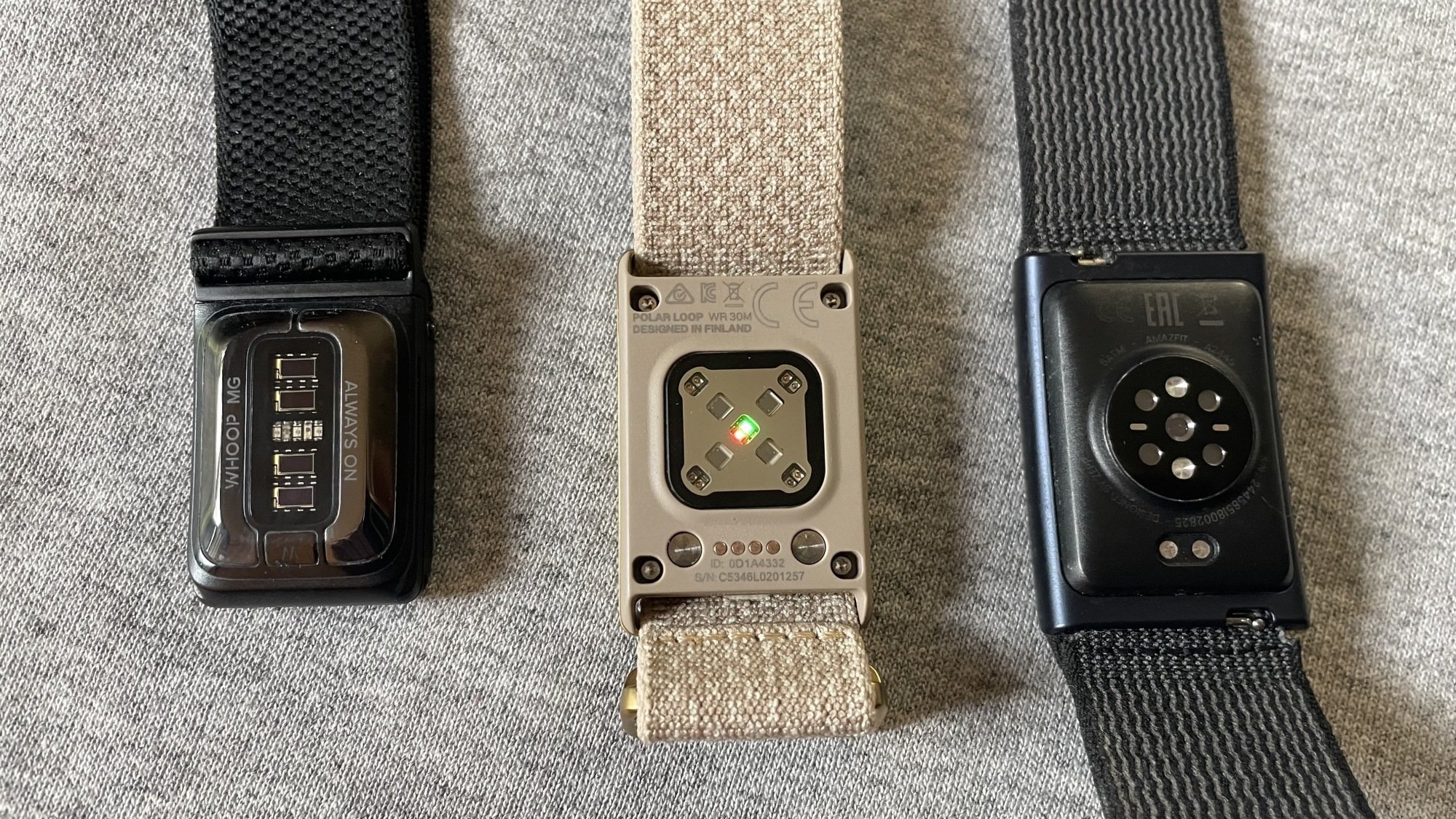 Sensor sides of the Whoop MG, Polar Loop, and Amazfit HelioStrap