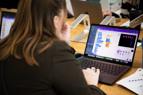 Photo of a person programming on Scratch on a laptop.