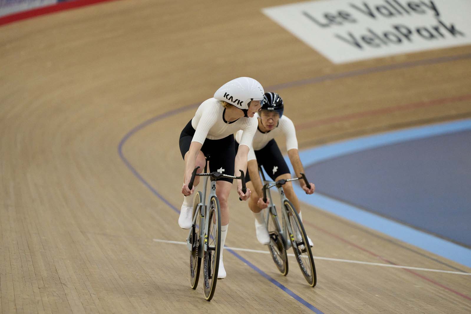 Two people racing Colnago T1Rs track bikes in velodrome.