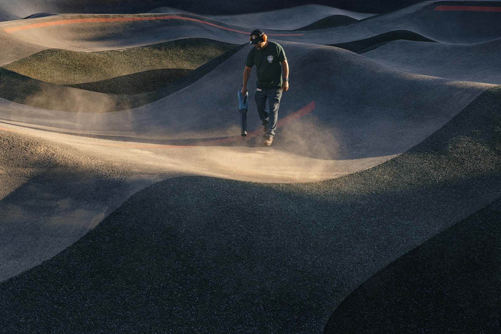 Man cleaning BMX pump track.