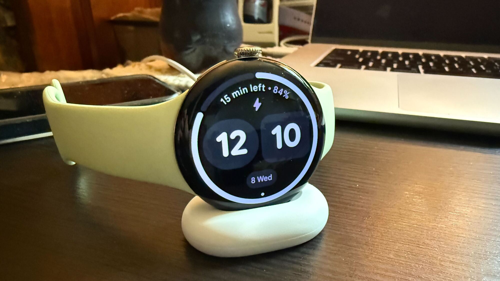 Pixel Watch 4 in the new charging dock, displaying time and battery percentage