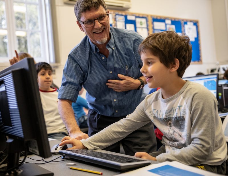 A boy and teacher in a computing class