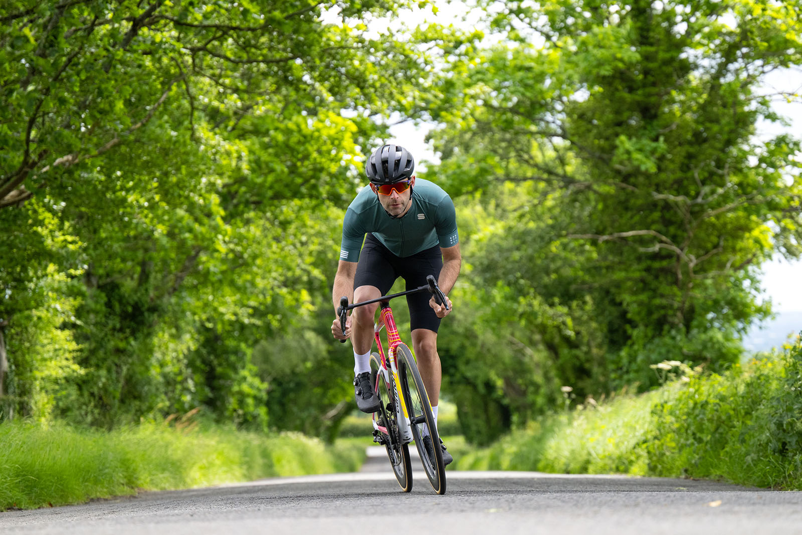 Male cyclist in green top riding the Cannondale Supersix Evo Lab71 EF Replica