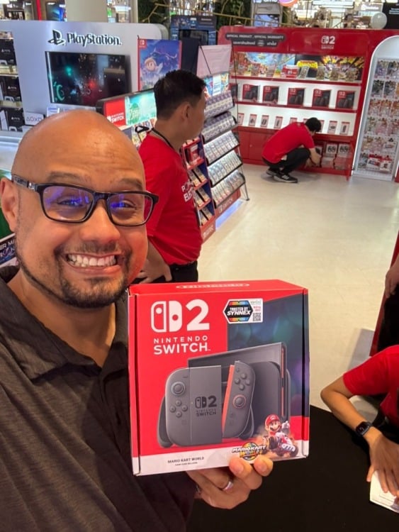 man holding a nintendo switch 2 box in a department store
