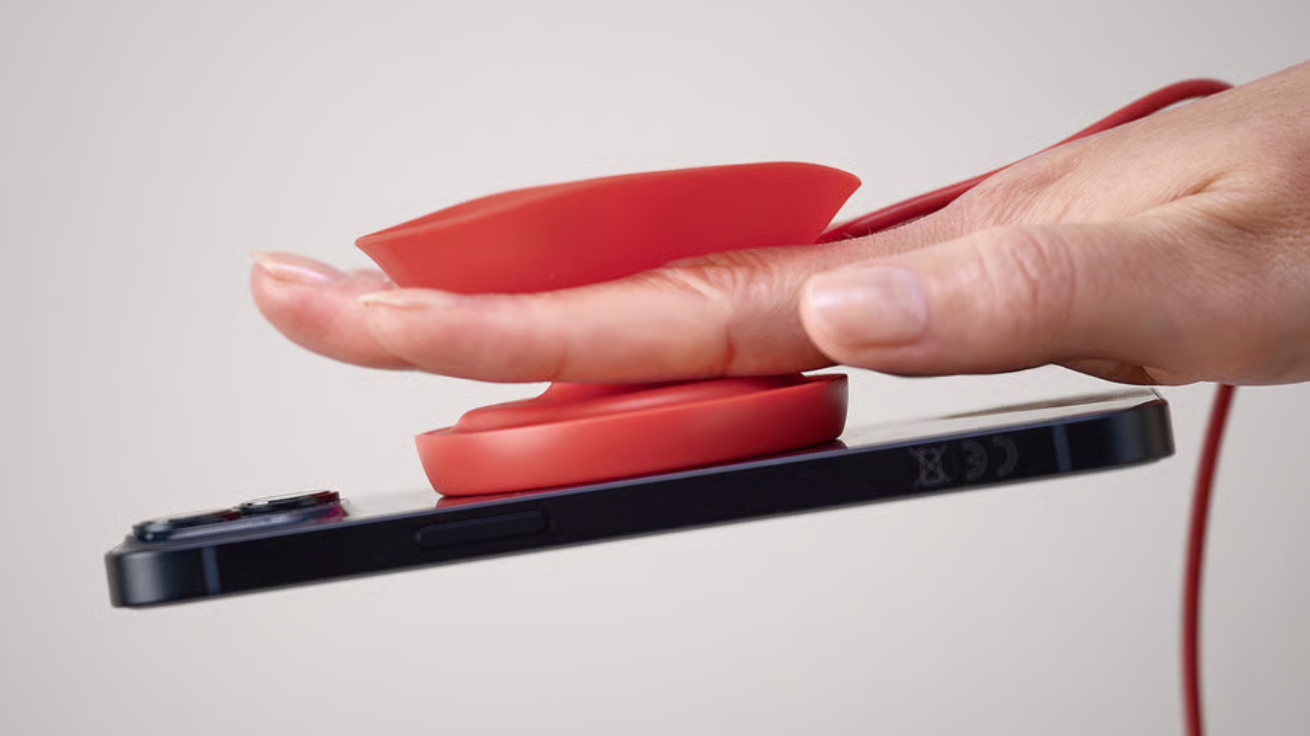 A VÄSTMÄRKE wireless charger with its top half unfolded so fingers can grip it.