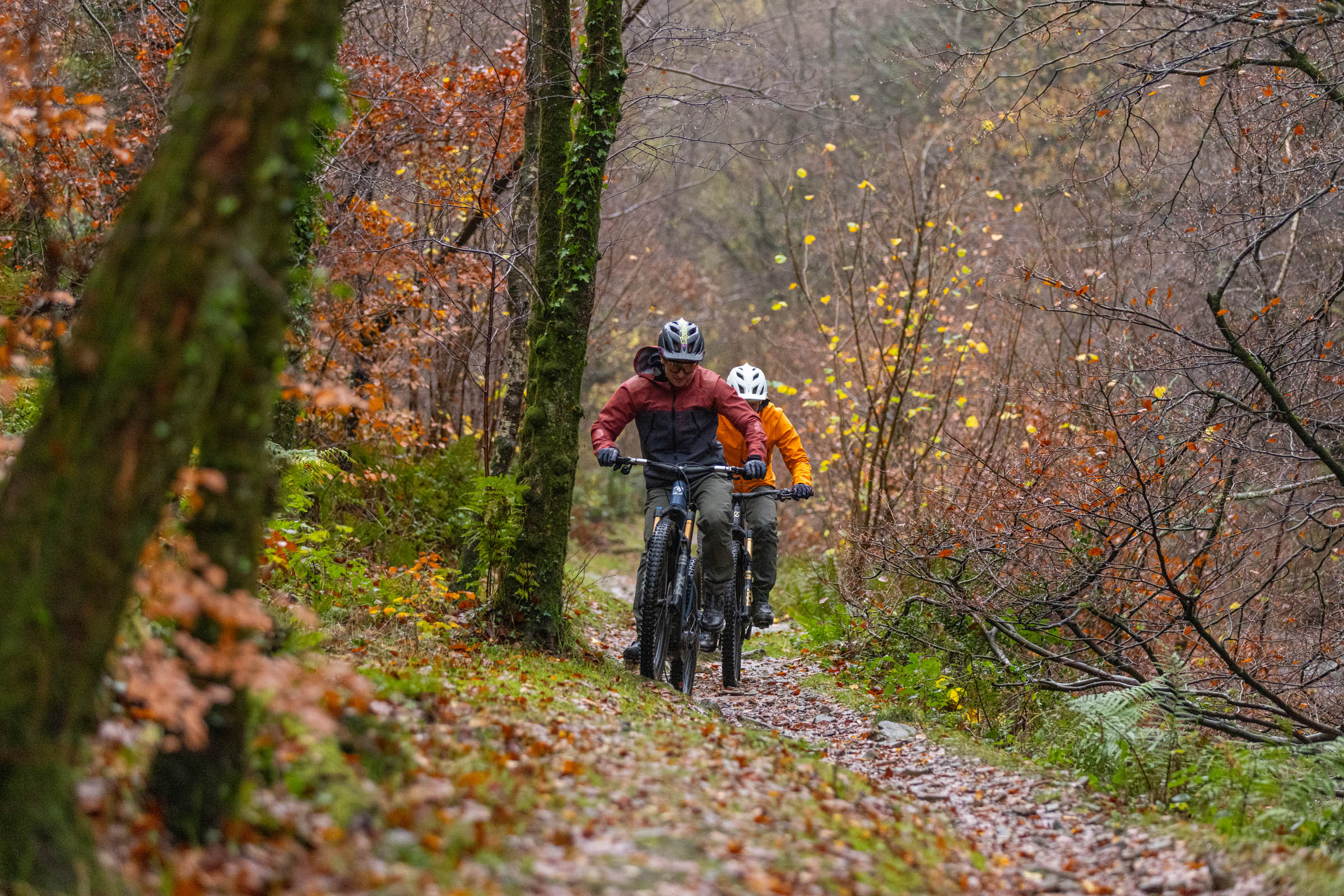 Pivot Shuttle AM and DJI Amflow electric mountain bikes ridden by two male mountain bikers