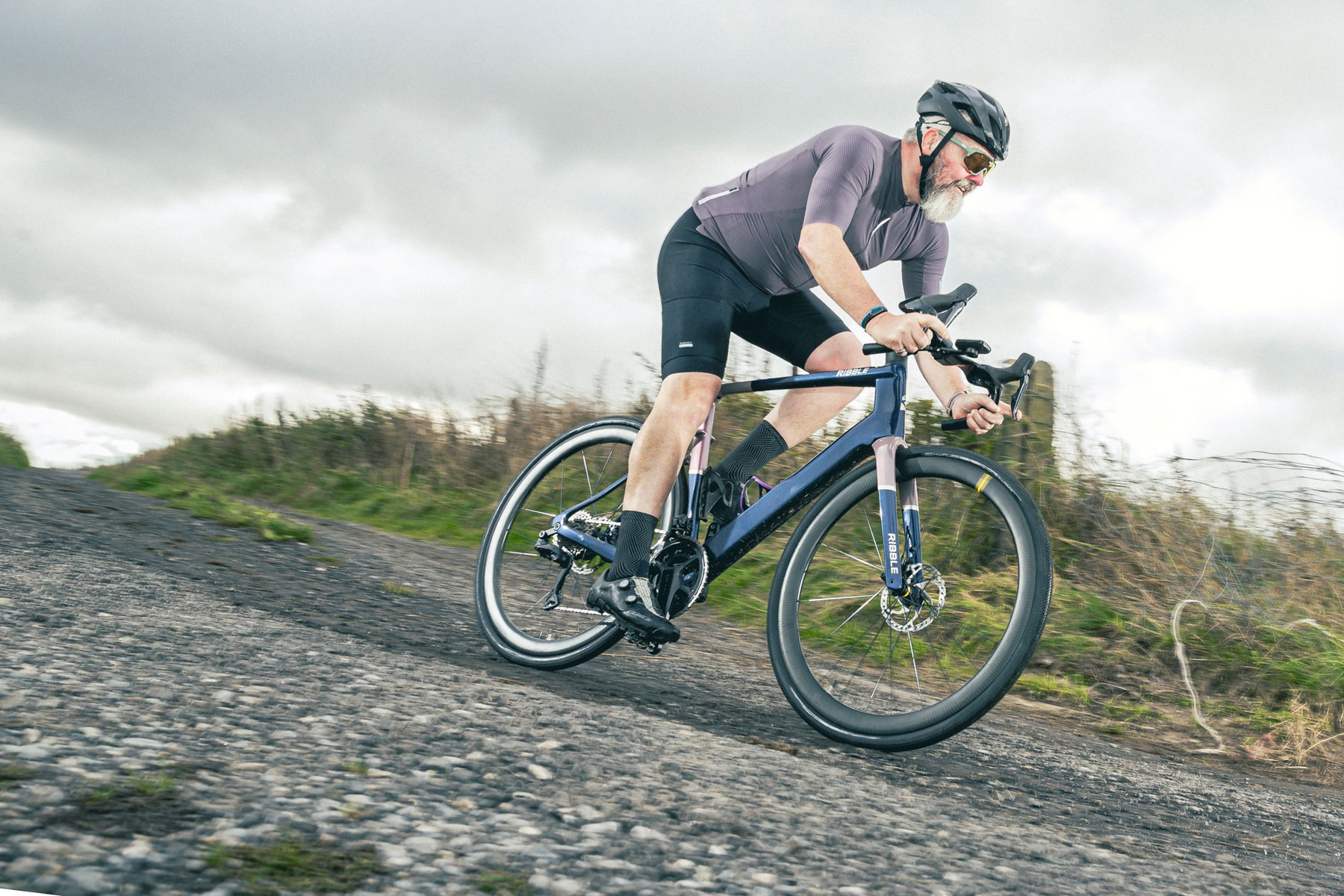 Male cyclist in purple top riding the Ribble AllRoad SL R e Pro All-Road/Gravel eBike