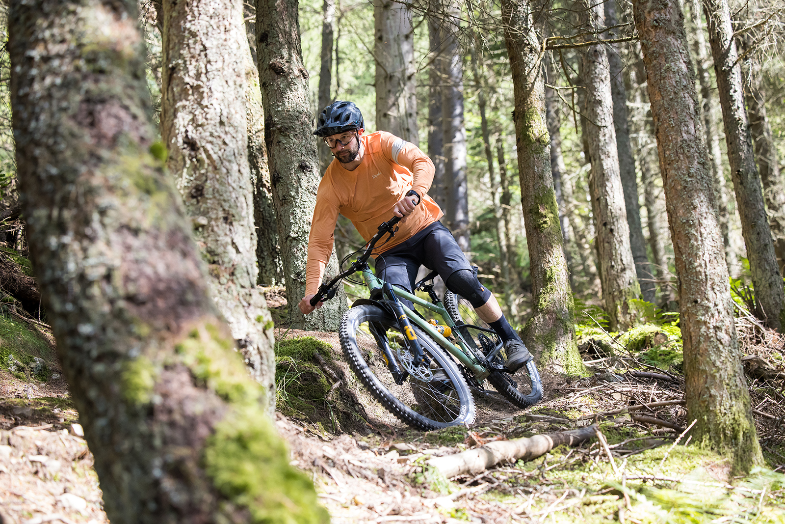 Male rider (Alex Evans) in orange top riding the Starling Murmur full suspension mountain bike