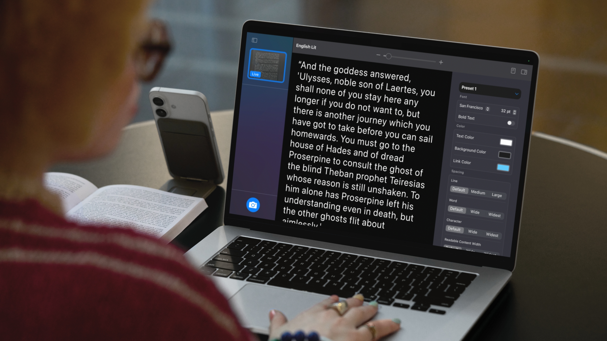 A MacBook using Magnifier and a connected iPhone to identify and format text from a book.