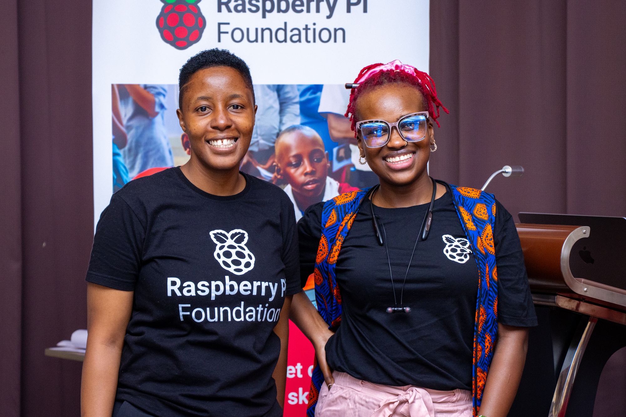 Two attendees of the Raspberry Pi Foundation's Kenya Partner Showcase 2025 smile at the camera.