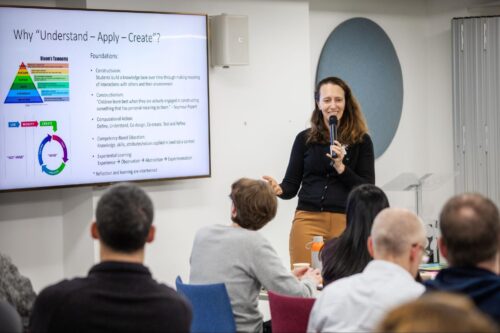 Photo of an educator presenting at the front of a classroom of other teachers.