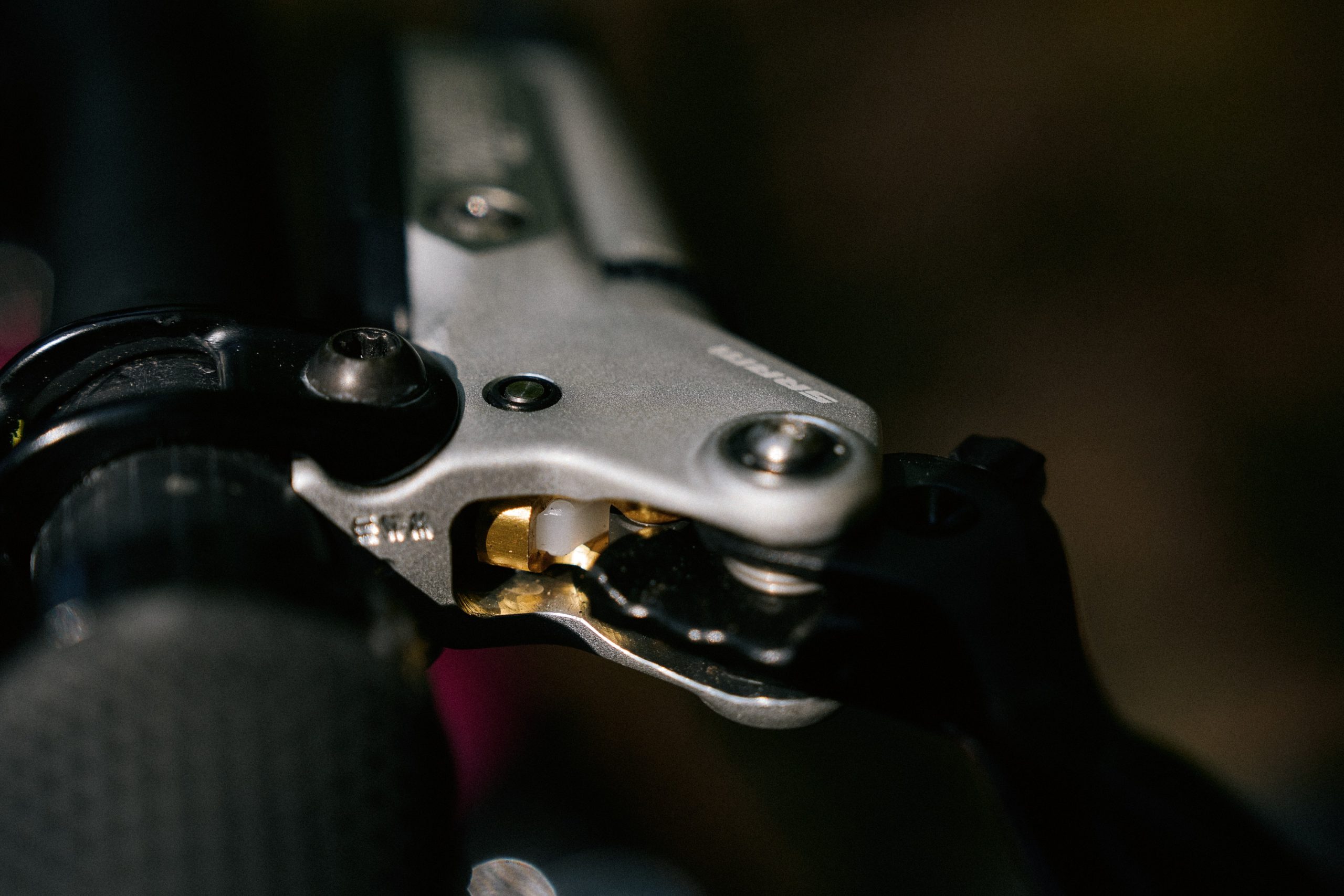 Shows small, golden SwingLink at the end of the new carbon lever blade on the SRAM Maven brakes.