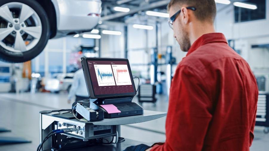 A person in an automotive factory, using the ThinkTab X11 tablet to look at graphs